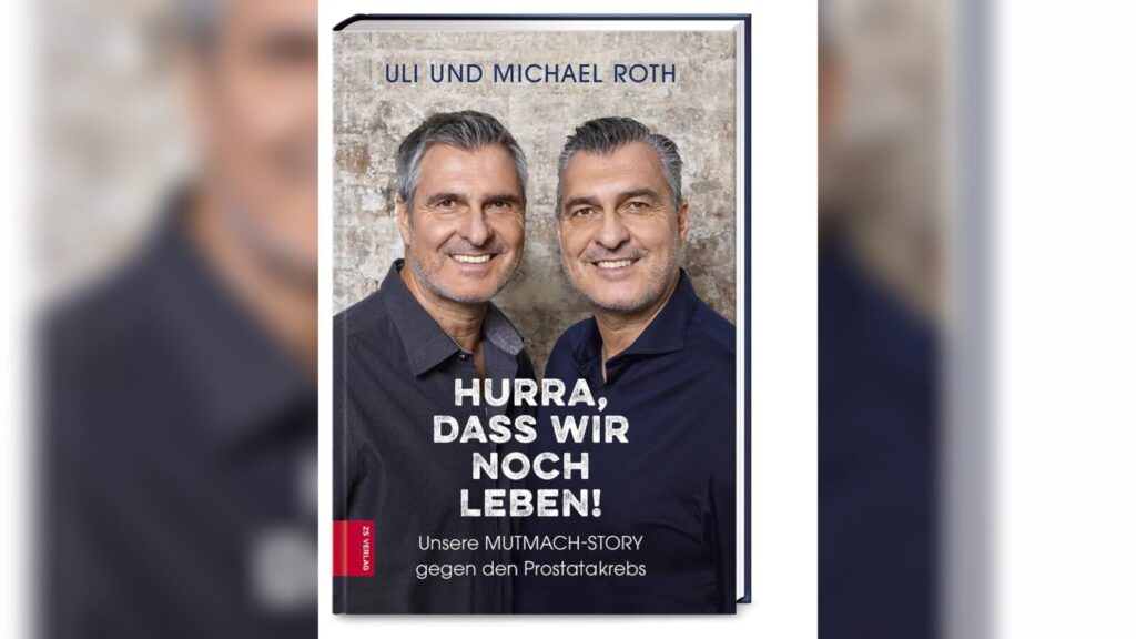 Buchcover: zwei lächelnde erwachsene Männer vor einer Wand; Titeltext: „Hurra, dass wir noch leben! Unsere Mutmach-Story gegen den Prostatakrebs.“